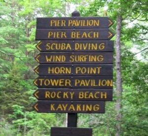 Fort Foster Park Kittery Maine a sign brown sign with yellow lettering pointing in different directions in a park