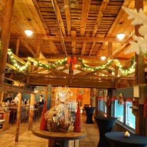 Holidays at Wiggly Bridge interior shot of the wiggly bridge outfitted for the chirstmas holiday, lights, green garland and red bows covering the walls and banisters