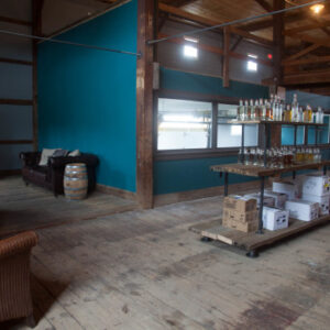 interior shot of the wiggly bridge barn, showing seating around a fireplace and table in the middle holding numerous wiggly bridge spirits and boxes