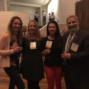 a group of 4 people at a Business After Hours event, smiling and posing