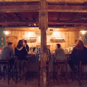 a group of people sitting at the Wiggly Bridge Distillery bar